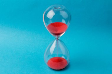 Kum saati ampulleri arasında akan ve bir geri sayım bitiş tarihine kadar geçen zamanı ölçen mavi arka planda fotokopi alanı olan bir kum..