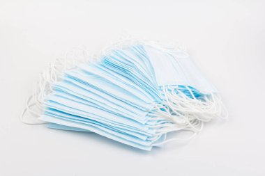 Mavi tıbbi maske beyaz arka planda izole edilmiş. Kirliliğe, virüse, gribe ve koronavirüse karşı yüz maskesi koruması. Sağlık ve Cerrahi Konsept.