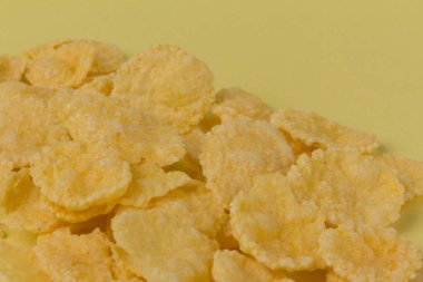 Sarı arka planda sarı mısır gevreği. Geleneksel sarı mısır gevreği, sağlıklı bir yaşam tarzı..