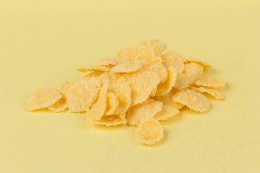 Sarı arka planda sarı mısır gevreği. Geleneksel sarı mısır gevreği, sağlıklı bir yaşam tarzı..