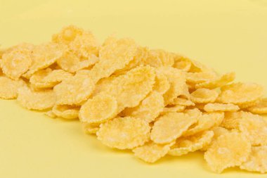 Sarı arka planda sarı mısır gevreği. Geleneksel sarı mısır gevreği, sağlıklı bir yaşam tarzı..