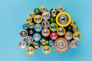 Composition with alkaline batteries on blue background. Chemical waste. Top view