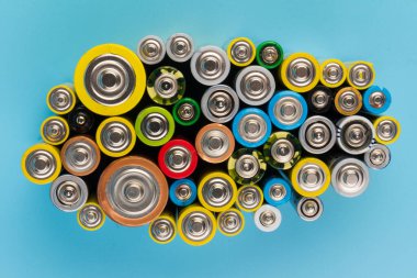 Composition with alkaline batteries on blue background. Chemical waste. Top view