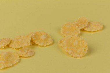 Sarı arka planda sarı mısır gevreği. Geleneksel sarı mısır gevreği, sağlıklı bir yaşam tarzı..