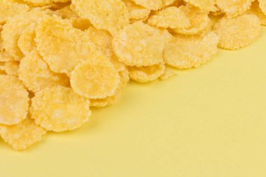 Sarı arka planda sarı mısır gevreği. Geleneksel sarı mısır gevreği, sağlıklı bir yaşam tarzı..