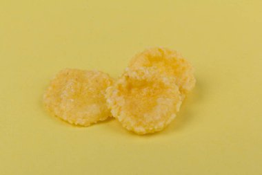 Sarı arka planda sarı mısır gevreği. Geleneksel sarı mısır gevreği, sağlıklı bir yaşam tarzı..