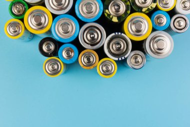 Composition with alkaline batteries on blue background. Chemical waste. Top view
