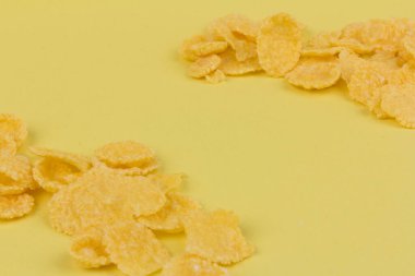 Sarı arka planda sarı mısır gevreği. Geleneksel sarı mısır gevreği, sağlıklı bir yaşam tarzı..