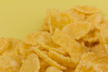 Sarı arka planda sarı mısır gevreği. Geleneksel sarı mısır gevreği, sağlıklı bir yaşam tarzı..