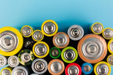 Composition with alkaline batteries on blue background. Chemical waste. Top view