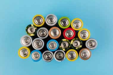 Composition with alkaline batteries on blue background. Chemical waste. Top view