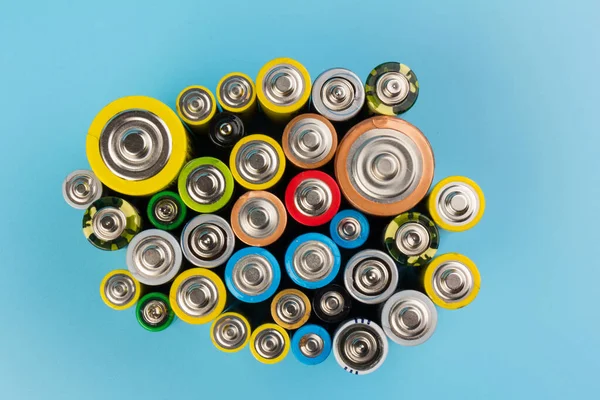 Composition with alkaline batteries on blue background. Chemical waste. Top view