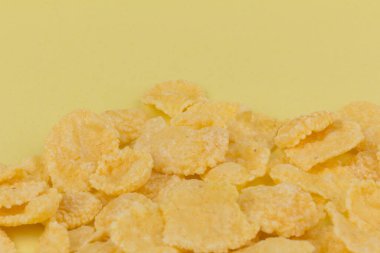 Sarı arka planda sarı mısır gevreği. Geleneksel sarı mısır gevreği, sağlıklı bir yaşam tarzı..