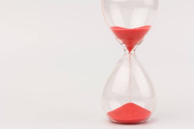 Kırmızı Kum, bir kum saatinin ampullerinin içinden geçerek bir geri sayım bitiş tarihine kadar geçen zamanı ölçüyor, fotokopi alanı olan beyaz bir arkaplanda..