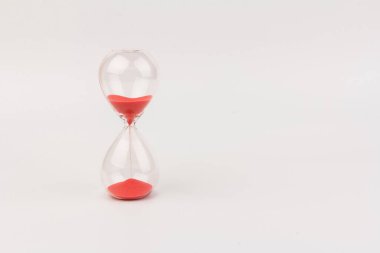 Kırmızı Kum, bir kum saatinin ampullerinin içinden geçerek bir geri sayım bitiş tarihine kadar geçen zamanı ölçüyor, fotokopi alanı olan beyaz bir arkaplanda..