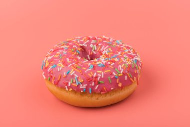 Çilek kremalı ve çok renkli donutlar, pembe arka planda izole edilmiş. Geleneksel tatlı hamur işleri. Metin için yer.