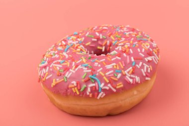 Çilek kremalı ve çok renkli donutlar, pembe arka planda izole edilmiş. Geleneksel tatlı hamur işleri. Metin için yer.