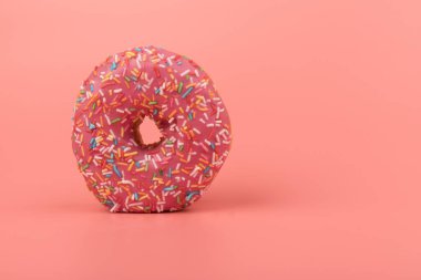 Çilek kremalı ve çok renkli donutlar, pembe arka planda izole edilmiş. Geleneksel tatlı hamur işleri. Metin için yer.