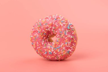 Çilek kremalı ve çok renkli donutlar, pembe arka planda izole edilmiş. Geleneksel tatlı hamur işleri. Metin için yer.