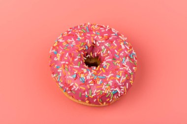 Çilek kremalı ve çok renkli donutlar, pembe arka planda izole edilmiş. Geleneksel tatlı hamur işleri. Metin için yer.