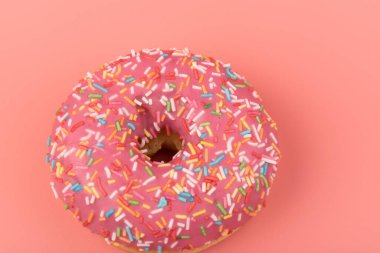 Çilek kremalı ve çok renkli donutlar, pembe arka planda izole edilmiş. Geleneksel tatlı hamur işleri. Metin için yer.