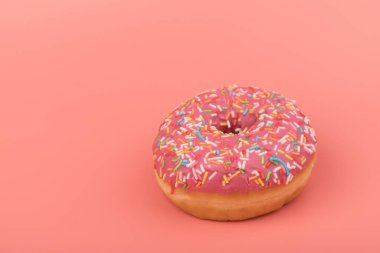 Çilek kremalı ve çok renkli donutlar, pembe arka planda izole edilmiş. Geleneksel tatlı hamur işleri. Metin için yer.