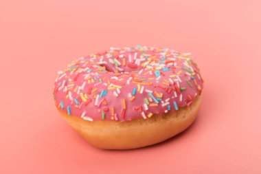 Çilek kremalı ve çok renkli donutlar, pembe arka planda izole edilmiş. Geleneksel tatlı hamur işleri. Metin için yer.