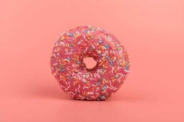 Çilek kremalı ve çok renkli donutlar, pembe arka planda izole edilmiş. Geleneksel tatlı hamur işleri. Metin için yer.