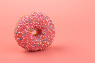 Çilek kremalı ve çok renkli donutlar, pembe arka planda izole edilmiş. Geleneksel tatlı hamur işleri. Metin için yer.