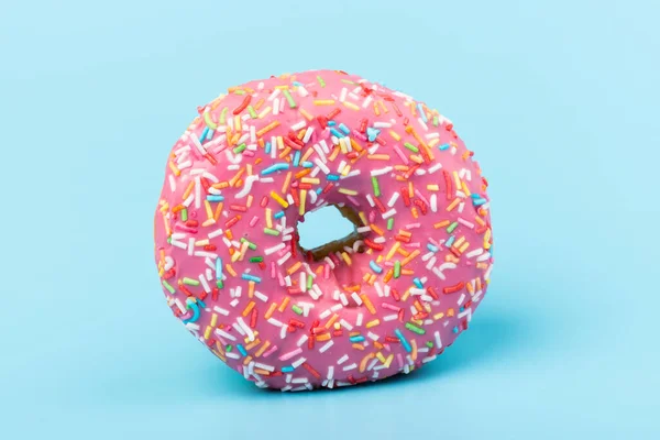 Çilek kremalı ve çok renkli donutlar, mavi arka planda izole edilmiş. Geleneksel tatlı hamur işleri. Metin için yer.