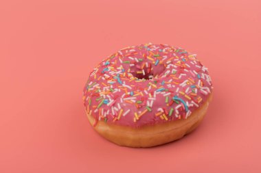 Çilek kremalı ve çok renkli donutlar, pembe arka planda izole edilmiş. Geleneksel tatlı hamur işleri. Metin için yer.