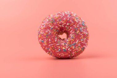 Çilek kremalı ve çok renkli donutlar, pembe arka planda izole edilmiş. Geleneksel tatlı hamur işleri. Metin için yer.