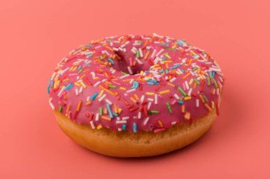 Çilek kremalı ve çok renkli donutlar, pembe arka planda izole edilmiş. Geleneksel tatlı hamur işleri. Metin için yer.