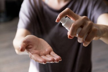 Kadının elinde dezenfekte edilmiş alkol ürünü var. Ellerin virüs bakterilerine karşı dezenfekte edilmesi, gündüz evde veya işte sağlığın korunması.