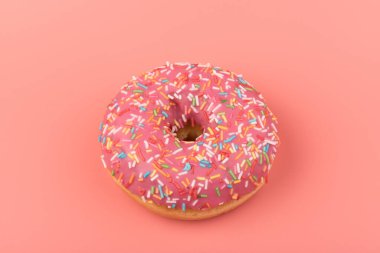 Çilek kremalı ve çok renkli donutlar, pembe arka planda izole edilmiş. Geleneksel tatlı hamur işleri. Metin için yer.