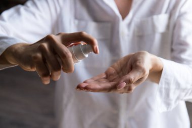 Kadının elinde dezenfekte edilmiş alkol ürünü var. Ellerin virüs bakterilerine karşı dezenfekte edilmesi, gündüz evde veya işte sağlığın korunması.