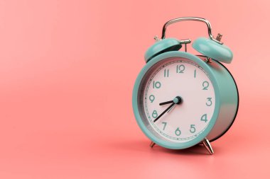 Pembe arka planda güzel bir retro mavi pastel alarm saati. Şimdi harekete geçme zamanı.