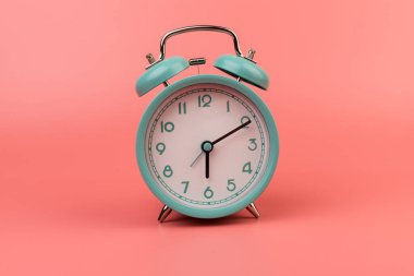 Pembe arka planda güzel bir retro mavi pastel alarm saati. Şimdi harekete geçme zamanı.