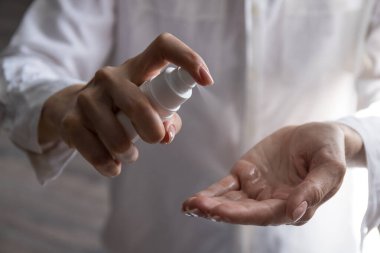 Kadının elinde dezenfekte edilmiş alkol ürünü var. Ellerin virüs bakterilerine karşı dezenfekte edilmesi, gündüz evde veya işte sağlığın korunması.