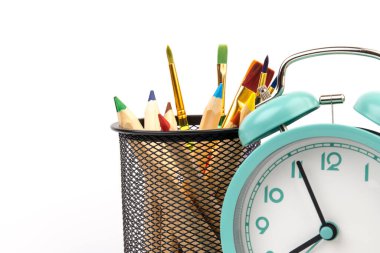 Beyaz arka planda çalar saat ve ofis malzemeleri olan stüdyo çalışma alanı. Kopyalama alanı ile