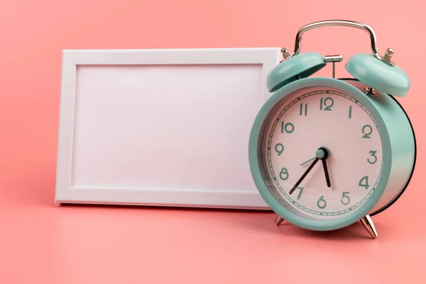 コピースペースとピンクのヴィンテージ目覚まし時計と白い写真フレーム — ストック写真
