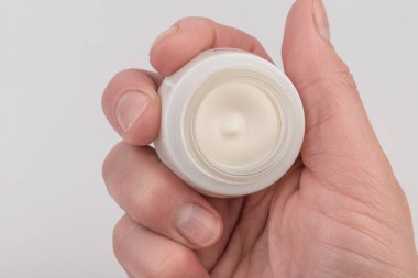 Mavi arka planda nemlendirici yüz kremi kabı. Moda kadını hala hayatta. Pop kadın şeyleri, ilaç ve kozmetik tema.