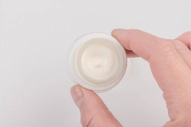 Beyaz arka planda nemlendirici yüz kremi kabı. Moda kadını hala hayatta. Pop kadın şeyleri, ilaç ve kozmetik tema.
