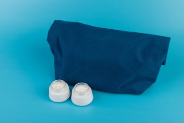 Kozmetik krem için kavanoz. El, ayak ya da yüz için. Mavi bez torbanın yanında. Temizlik, bakım konsepti. Boşluğu kopyala