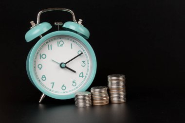 İş metaforu kavramı para kavramı demektir. Siyah arkaplanda mavi alarm ve bozuk paralar