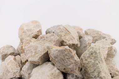 Gri küçük kayaların zemin dokusu beyaz arka planda izole edilmiş. Küçük bir yol taşı. Çakıl taşları. Ezilmiş granit çakıl, yakın çekim.. 