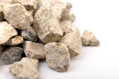 Gri küçük kayaların zemin dokusu beyaz arka planda izole edilmiş. Küçük bir yol taşı. Çakıl taşları. Ezilmiş granit çakıl, yakın çekim.. 