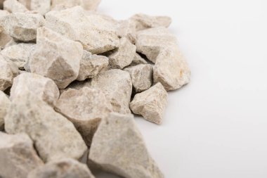 Gri küçük kayaların zemin dokusu beyaz arka planda izole edilmiş. Küçük bir yol taşı. Çakıl taşları. Ezilmiş granit çakıl, yakın çekim.. 