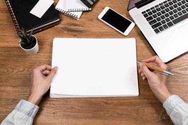 Bilgisayarlı çalışma alanı, kadın eli, defter, gözlük, çizim defteri, ahşap masa. Üst kattaki ofis masasında yatıyordu. Serbest İşyeri. 