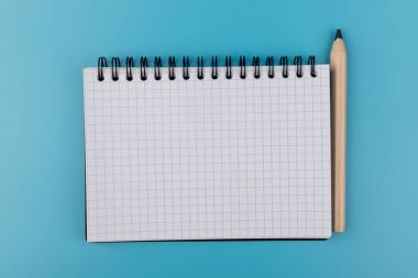 Kalemler ve boş defterler mavi arkaplanda kopyalama alanı ile